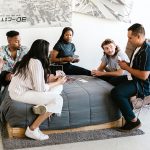 young university students playing cards on a bed in a dorm