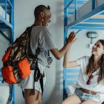 Women High Fiving in a Dorm Room with Bunk Beds